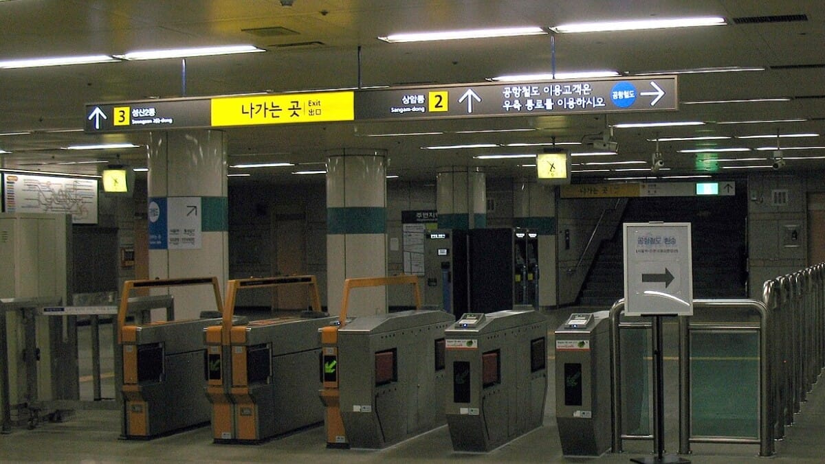 Tourist tapping a T-money card at a Seoul subway gate
