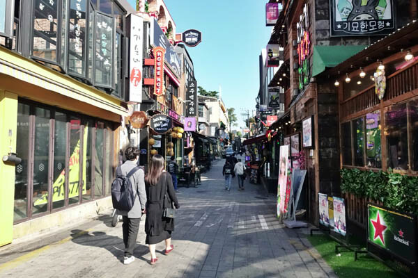 Pedestrians on a narrow commercial street in Seoul