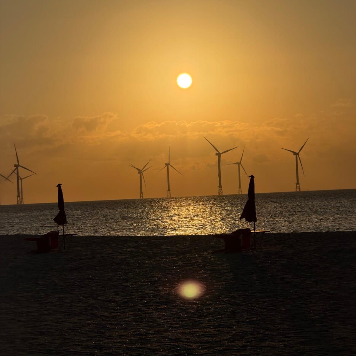 Sunset over the sea and offshore wind turbines at Gwakji Beach on Jeju Island