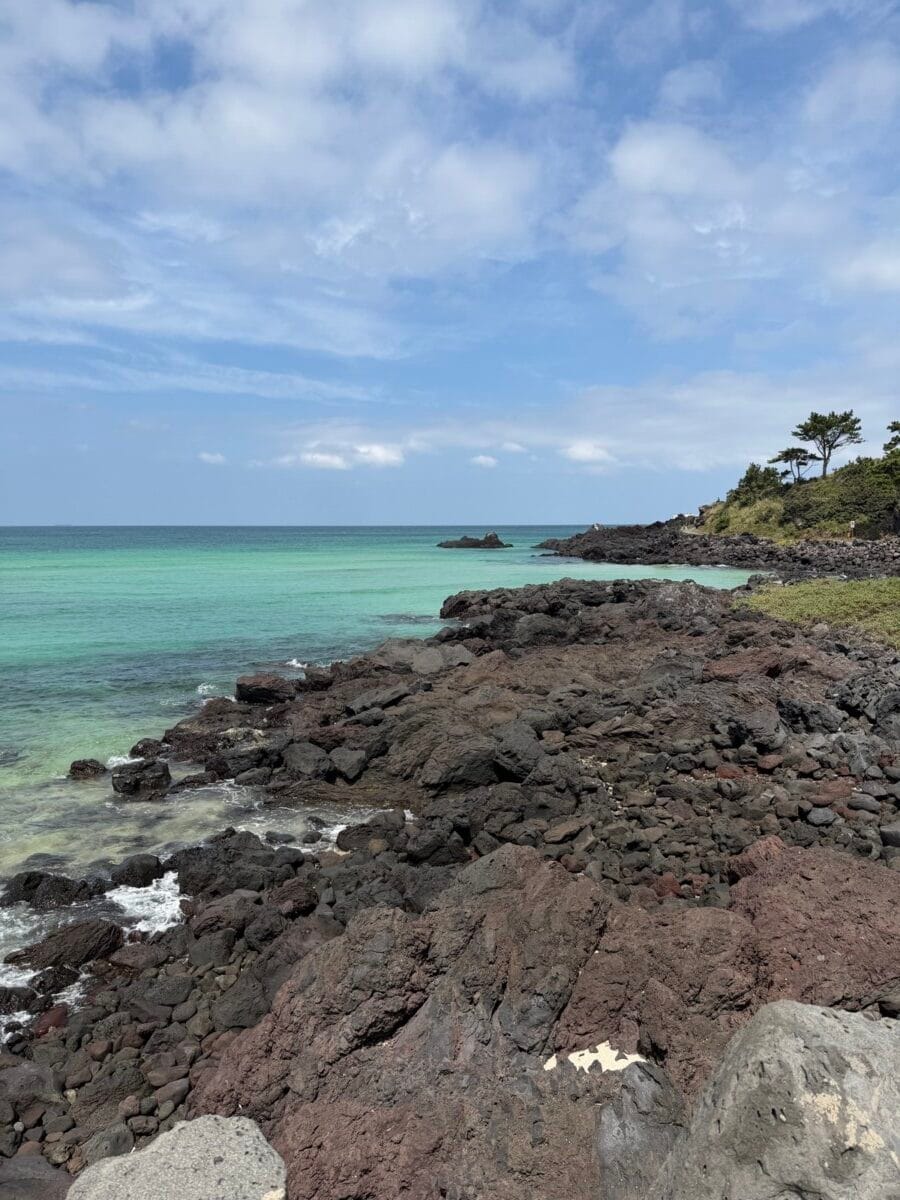 Clear blue water and black volcanic rocks at Gwakji Gwamul Beach on Jeju Island