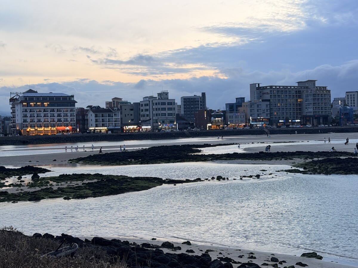 Hamdeok Beach shoreline and buildings at dusk