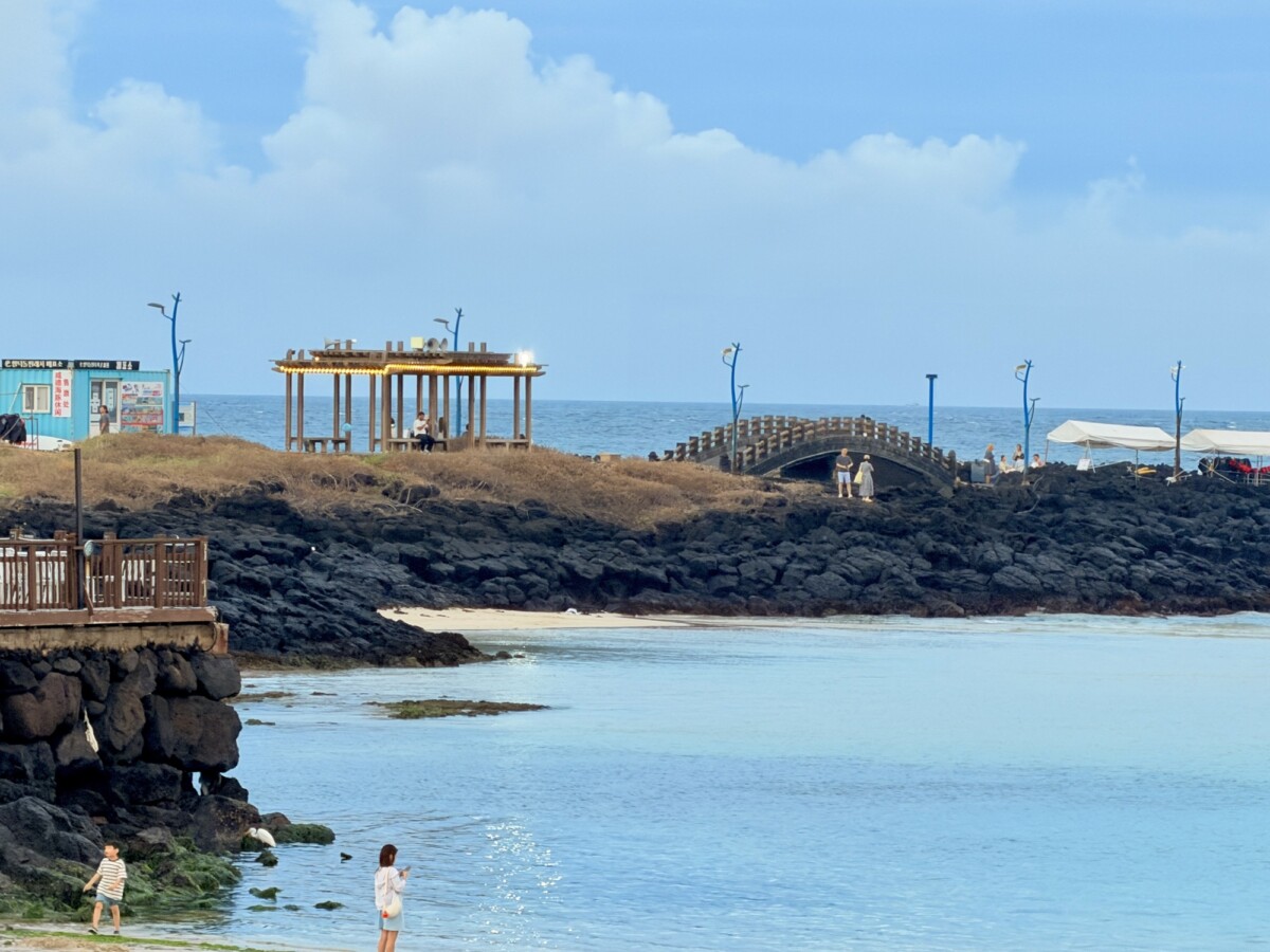Shallow blue water and volcanic rock at Hamdeok Beach