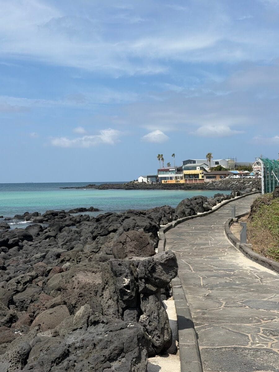 Black volcanic rocks and coastal walking path along Handam in Aewol, Jeju Island