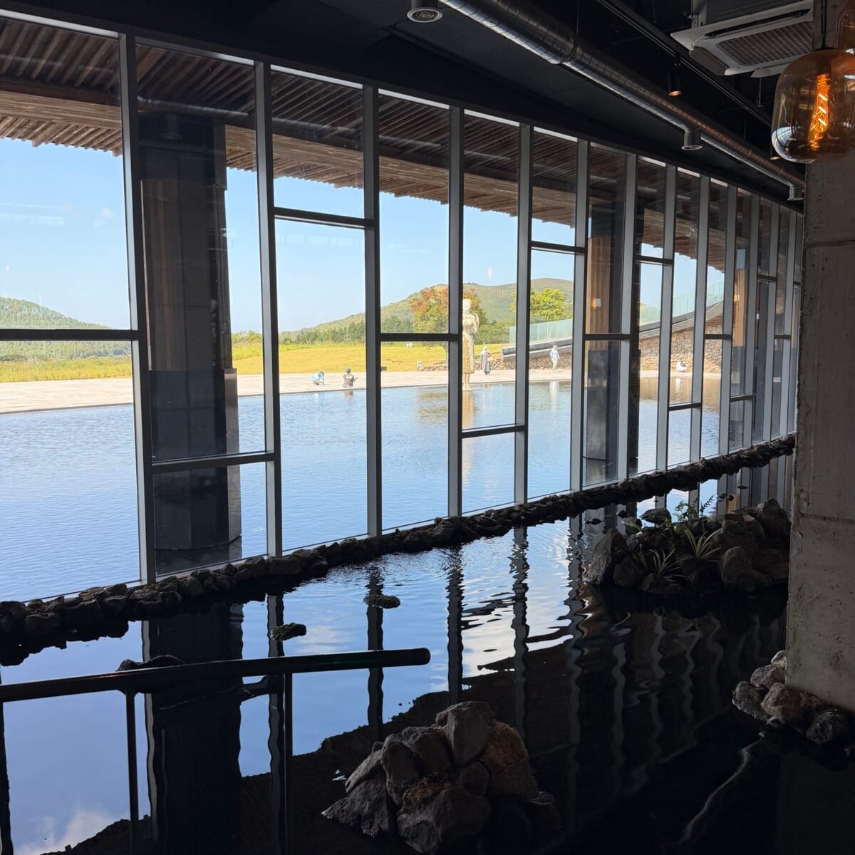 Indoor water feature and large windows inside Jejudang Bakery Cafe in Jeju Island